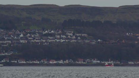 Town-home-apartments-look-down-on-coastal-waterway-as-ferry-crosses