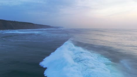 Strong-high-waves-of-Atlantic-Ocean-crashing-in-Magoito-Beach,-Portugal-during-blue-hour