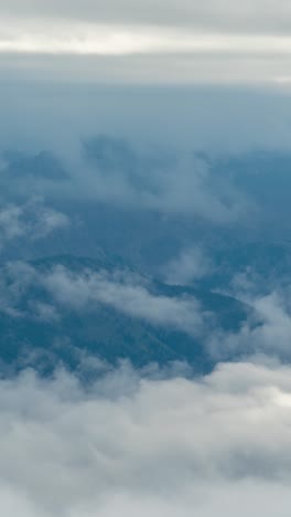 Vertikaler-4K-Zeitraffer,-Wolken-Und-Dichte-Nebelinversionen-über-Tälern-Und-Hohen-Berggipfeln