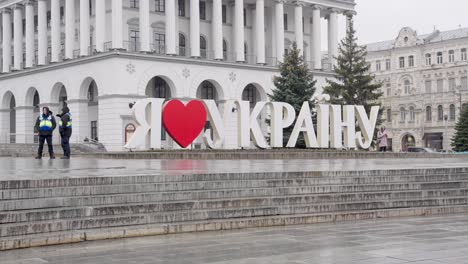 Ich-Liebe-Die-Ukraine-Schild-Mit-Rotem-Herz-Und-Sicherheitsleuten-Am-Unabhängigkeitsplatz