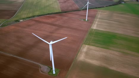 Alignment-of-wind-turbines-on-a-line,-drone-shot-over-the-installations