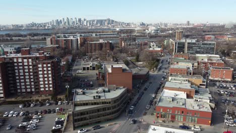 Aerial-view-of-Saint-Lambert-city-in-southwestern-Quebec,-Canada,-with-saint-Lawrence-River,-and-Montreal-cityscape-skyline-in-background-during-a-sunny-day-clear-sky-drone-footage