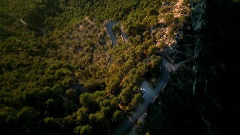 Aerial-view-of-winding-road-in-lush-greenery-at-Sant-Salvador-Mallorca