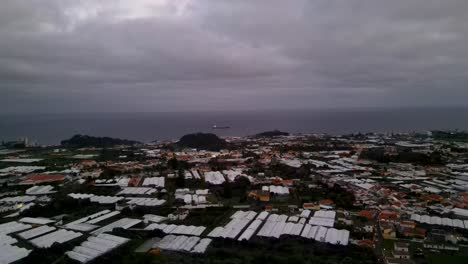 An-aerial-view-captures-a-residential-enclave-nestled-near-the-sea,-adorned-with-vibrant-rooftops,-including-the-pineapple-factory-district,-embodying-the-essence-of-coastal-living-and-local-industry