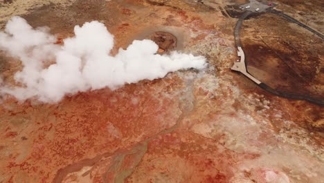 Gunnhuver-hot-springs-in-iceland-with-steam-and-vibrant-terrain,-aerial-view