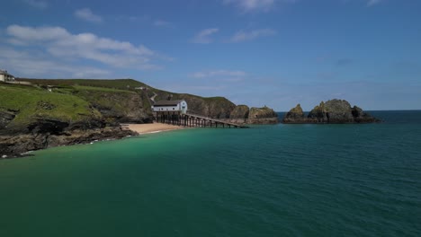 Estación-De-Botes-Salvavidas-Rnli-Padstow-Con-Drone-Aéreo-Bajo-Sobre-Aguas-Costeras-De-Cornualles,-Reino-Unido