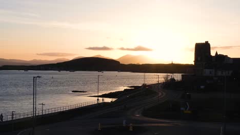 Goldener-Sonnenuntergang-über-Der-Oban-Bay-Mit-Silhouetten-Von-Gebäuden-Und-Landschaft-Und-Ruhigem-Meerwasser-Im-Westen-Schottlands,-Vereinigtes-Königreich