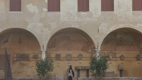 Lone-Woman-Passing-On-The-Archways-Of-Historic-Building