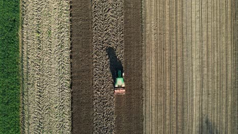 View-from-Above-of-Tractor-Cultivating-Soil-for-Spring-Planting-on-a-Beautiful-Morning,-Agricultural-Theme-in-the-Background