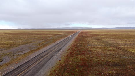 Carretera-Vacía-Que-Se-Extiende-A-Lo-Lejos-En-El-Vasto-Paisaje-De-Islandia,-Cielo-Nublado