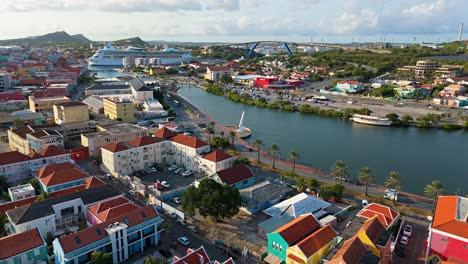 Cruise-ship-docked-in-Willemstad-Curacao-port,-panoramic-city-establishing