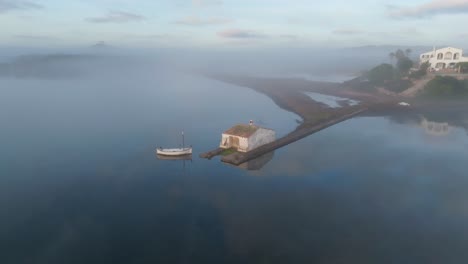 Aerial-Drone-Fly-above-mediterranean-bay-houses-seclude-location-in-Foggy-Island