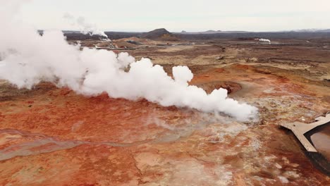 Steam-rising-from-colorful-gunnhuver-hot-springs-in-iceland,-aerial-view