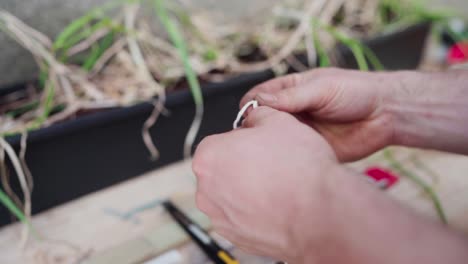 Human-Hand-Tightening-Loop-Of-A-White-Yarn-Thread