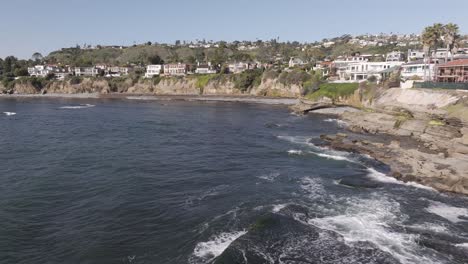 Low-aerial-view-of-homes-near-a-cliff-in-San-Diego,-California-on-a-sunny-day