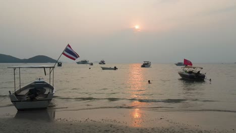 Luftaufnahme-Eines-Tiefflugs-An-Einem-Kleinen-Boot-Vorbei,-Das-Während-Des-Sonnenuntergangs-Zur-Goldenen-Stunde-Am-Strand-Von-Ao-Suan-Yai-Auf-Der-Insel-Koh-Mak-Festgemacht-Ist