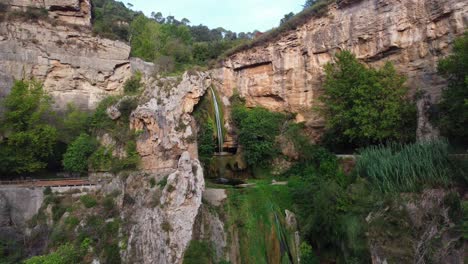 Impresionante-Vista-De-La-Cascada-De-Sant-Miquel-Del-Fai-En-Barcelona,-Rodeada-De-Exuberantes-Acantilados.