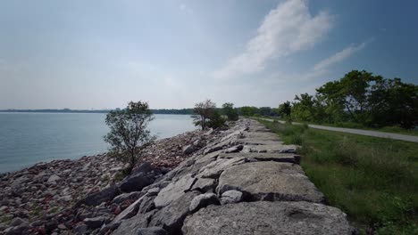 taking-a-walk-by-the-rocky-lakeshore-bank-in-sunny-day