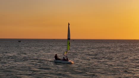 Private-Sunset-Sailing-Classes-In-Southeast-Asia,-Vietnam:-Low-Aerial-Tracking-Shot-Of-A-Dinghy-Sailboat