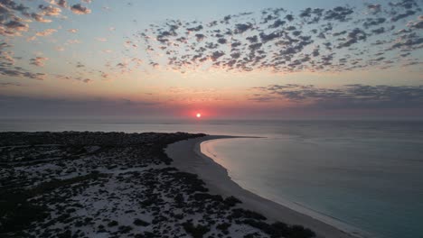 Sunset-over-the-horizon-with-cloud-formation-across-the-sky,-drone-dolly-shot