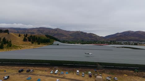 Aerial-view-of-flying-helicopter-over-orchard-during-heavy-rain-in-New-Zealand