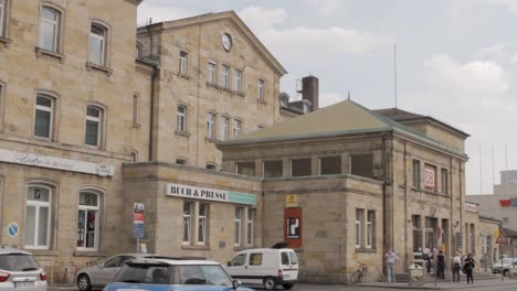 Historischer-Europäischer-Bahnhof-An-Einem-Bewölkten-Tag,-Mit-Fußgängern-Und-Autos-Draußen