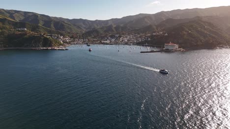 Avalon-on-catalina-island-with-boats-cruising-in-sunlit-waters,-aerial-view