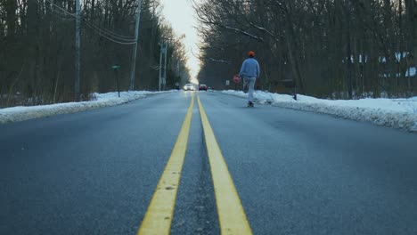 Man-skates-down-the-road-in-the-winter