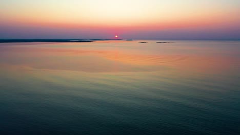 Ende-Des-Ruhigen-Sonnenuntergangs-Am-Meer-Mit-Schwach-Beleuchteter-Sonne-über-Kleinen-Inseln-Am-Horizont