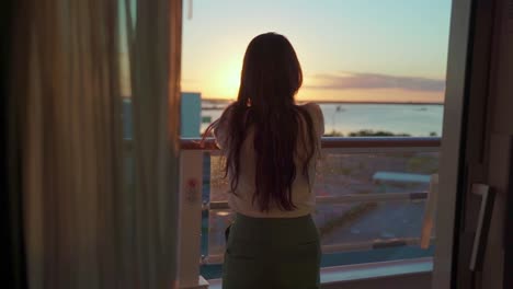 Woman-looking-out-to-sea-on-the-cruise-in-the-evening-sunset-back-shot-slow-middle