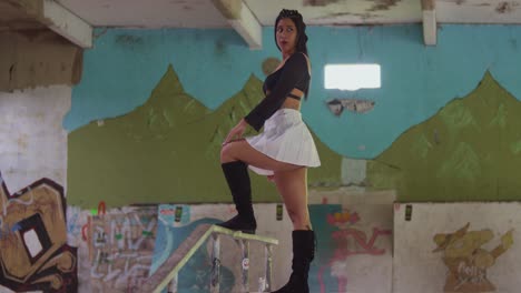 In-her-mini-skirt,-a-Hispanic-girl-exudes-confidence-as-she-glides-through-the-indoor-skatepark-with-her-skateboard