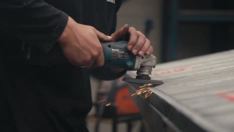 Worker-using-industrial-grinder,-slow-motion