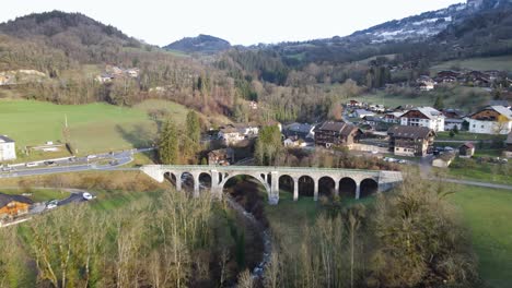 Closing-in-on-white-stone-arc-bridge-in-French-village