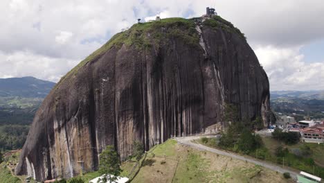 Massive,-impressive-rocky-mountain-El-Penon-in-Guatape,-Colombia,-aerial