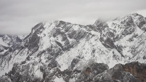 A-thin-layer-of-snow-on-the-dark-racks,-Aerial-view-of-the-Austrian-Alps