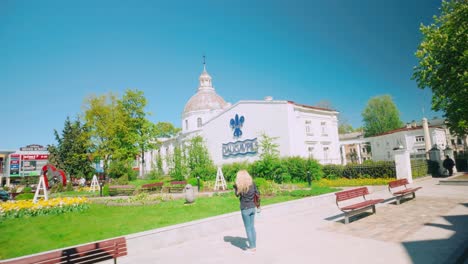 Daugavpils-Historisches-Stadtzentrum-Mit-Kirche,-Lettischer-Flagge,-Park-Und-Bänken,-Niederländischer-Blickwinkel,-Reisen