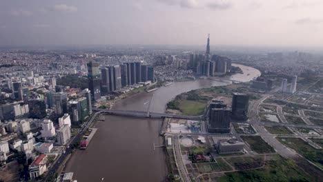 Aerial-view-of-the-Ba-Son-Bridge-over-the-Saigon-River-in-Ho-Chi-Minh-City,-Vietnam,-with-the-view-of-Landmark-81-building,-tower-in-the-background