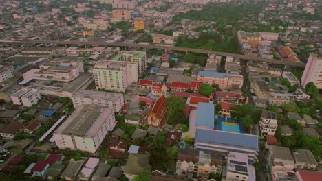 Aerial-orbit-large-Buddhist-temple-with-red-roof-in-Bangkok,-Thailand