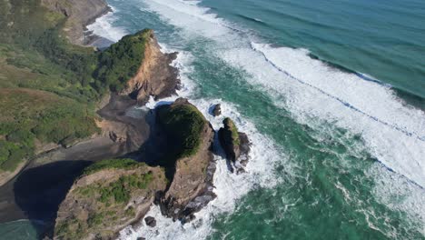 Vista-Aérea-De-La-Enorme-Roca-De-La-Isla-Taitomo-En-El-Sur-De-La-Playa-De-Piha-En-La-Costa-Oeste-De-Auckland,-Nueva-Zelanda