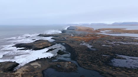 Rugged-black-volcanic-coastline-and-stormy-Atlantic-ocean,-Iceland