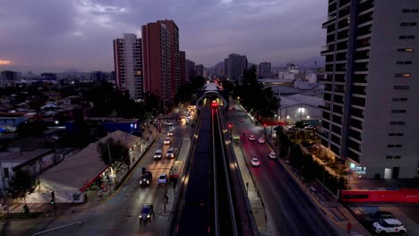 Aérea:-Frente-A-Un-Metro,-Saliendo-De-Una-Estación-De-Metro,-Tarde-En-Santiago-De-Chile