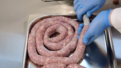 Der-Metzger-Füllt-Schweinedärme-Mit-Einer-Mischung-Aus-Rind--Und-Schweinefleisch-Und-Stellt-So-Wurst-Her,-Die-Für-Die-Wärmebehandlung-Im-Ofen-Bestimmt-Ist.