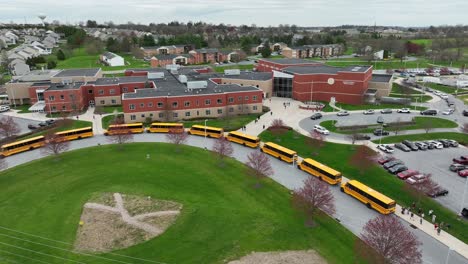 Row-of-American-school-buses-waiting-for-children-in-front-of-school