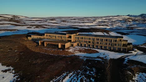 Drone-shot-of-hotel-in-iceland-during-winter-and-sunrise,-landscape