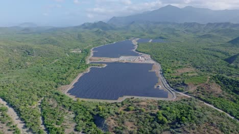 Aerial-wide-shot-of-solar-panel-farm-surrounded-by-scenic-area-of-Dominican-Republic