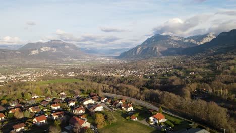 Zeitraffer-Eines-Autos,-Das-Durch-Die-Hauptstraße-Fährt,-Mit-Einer-Europäischen-Stadt-Mit-Gebäuden-Mit-Roten-Dächern-Und-Einer-Stadt-Mit-Wolkenkratzern-Und-Bergen-Im-Hintergrund