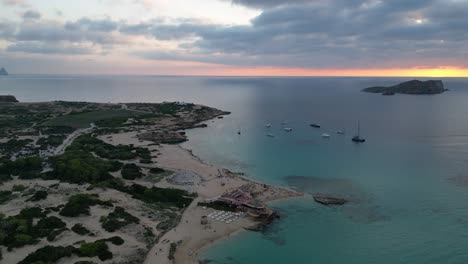 Strand-Von-Cala-Comte-Mit-Booten,-Atemberaubender-Sonnenuntergangshimmel-Auf-Ibiza