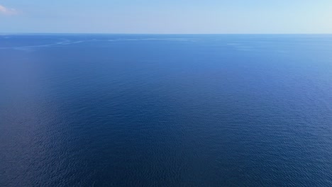 Stunning-panoramic-aerial-overview-of-nature's-beautiful-ocean-water-with-currents-in-distance