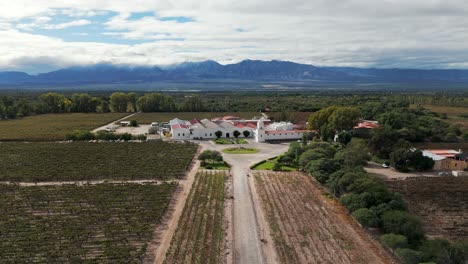 Aerial-view-reveals-the-beauty-of-a-renowned-bodega-nestled-in-the-Cafayate-Valley,-Salta,-Argentina,-known-for-crafting-exquisite-high-altitude-wines