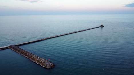 4K-Aerial-Flyover-Port-Washington-Harbor,-Pedestrian-Walkway,-And-Pierhead-Light-On-The-Western-Shore-Of-Lake-Michigan,-Milwaukee,-Wisconsin